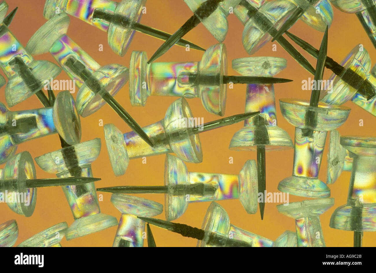 Clear thumbtacks with orange background Stock Photo
