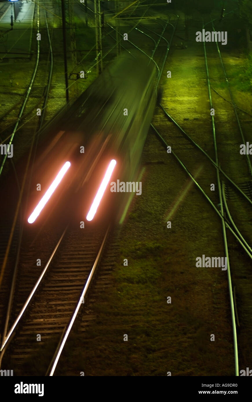 Train Engine Pulling into a Railway Station at Night Stock Photo