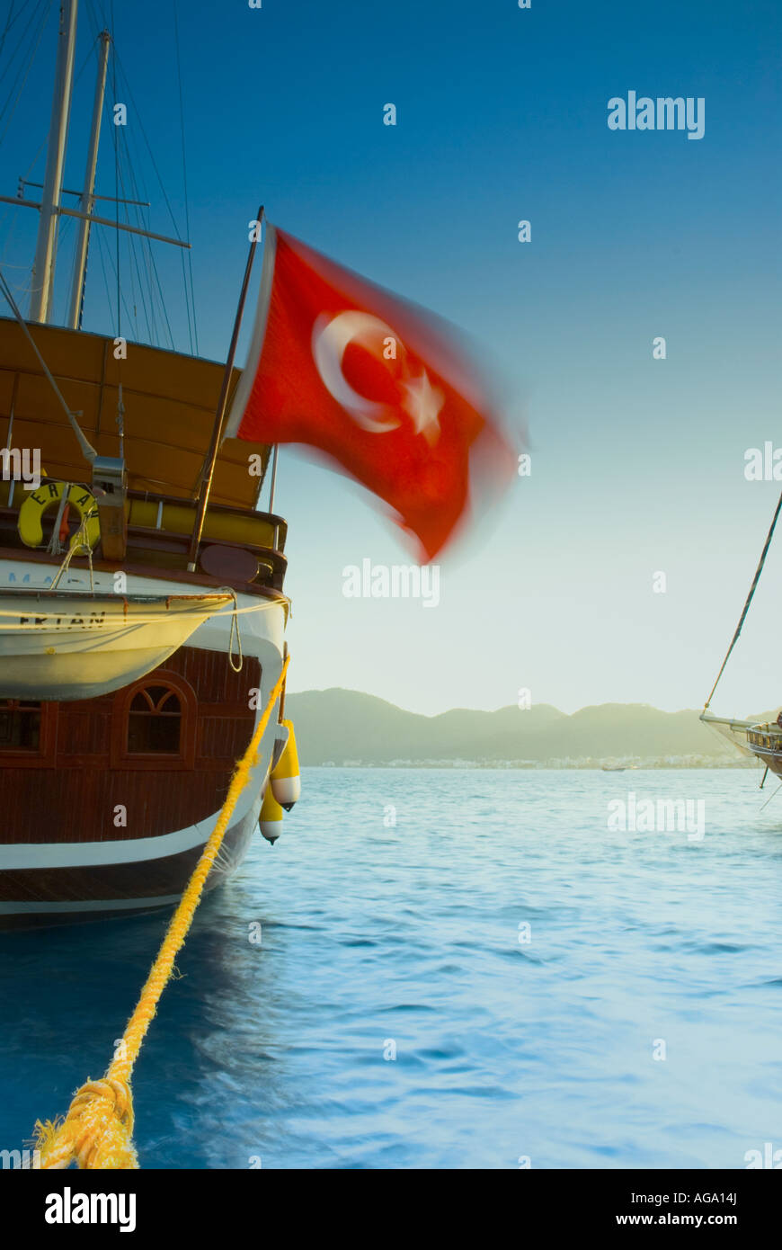 A Gulet (Turkish Yacht) moored in Marmaris Marina. Fluttering motion-blurred Turkish Flag. Stock Photo
