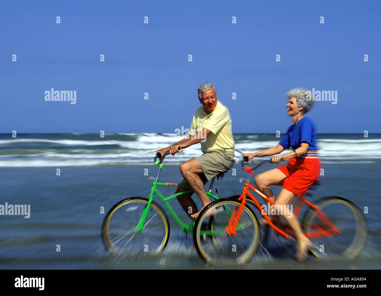 Retired couple riding bikes on vacation at the beach Stock Photo - Alamy