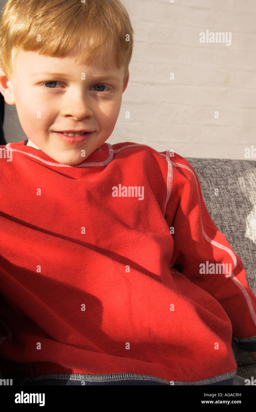 portrait of young boy wearing red jumper Stock Photo Alamy
