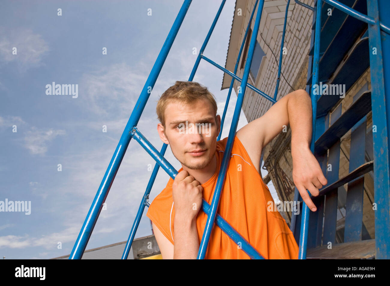 portrait of young man looking through railing Stock Photo - Alamy