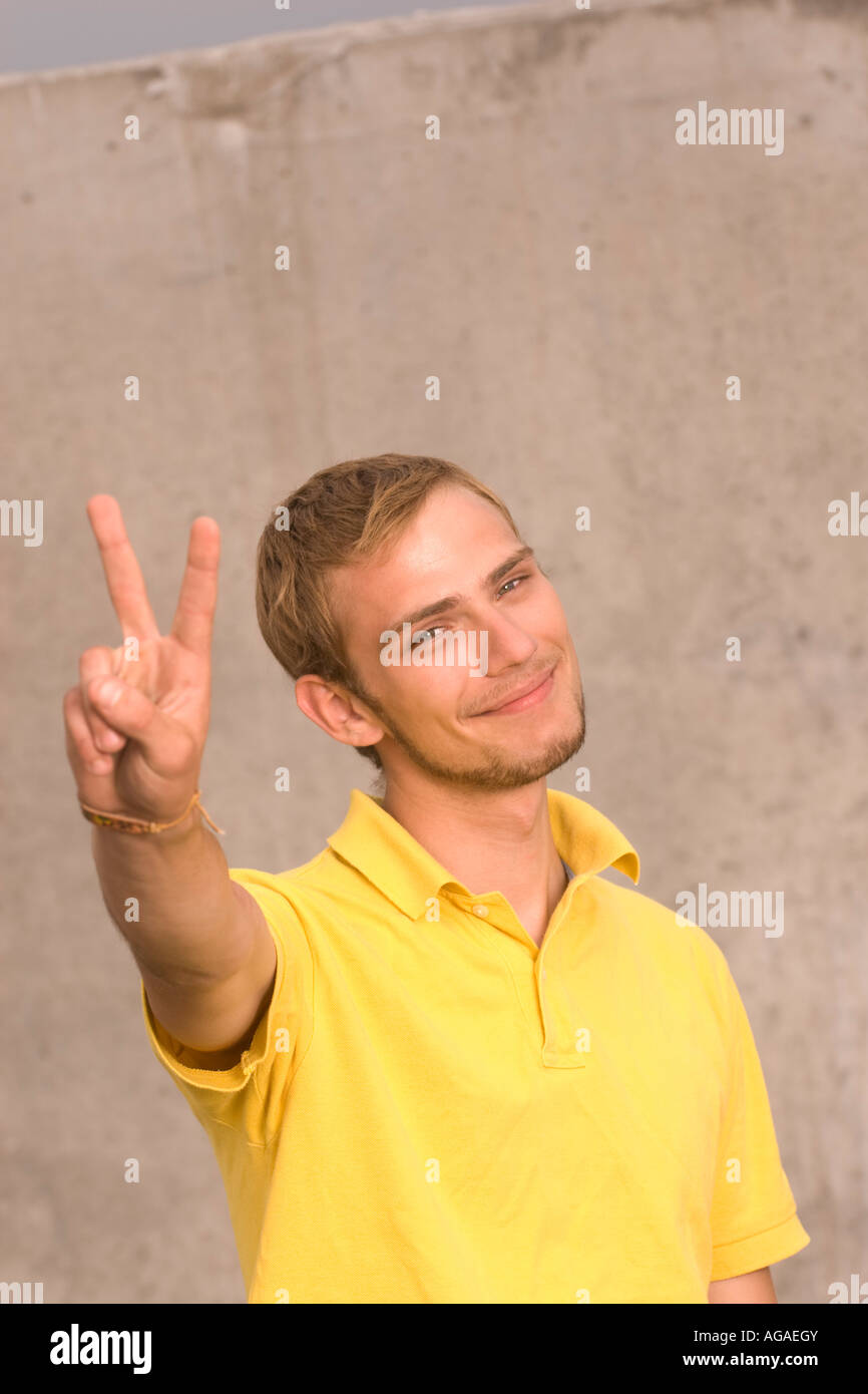 portrait of young man doing the victory sign Stock Photo