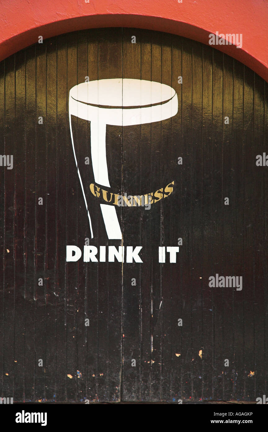 A door facing the street painted with a Guinness beer advertisement. Stock Photo