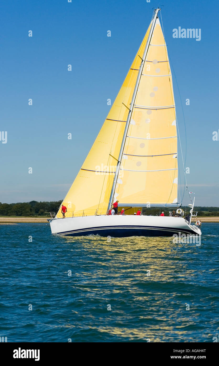 A fully crewed racing yacht sailing on a glorious summer's day Stock Photo