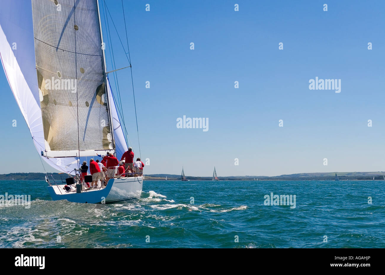 A fully crewed racing yacht sailing on a glorious summer's day Stock Photo