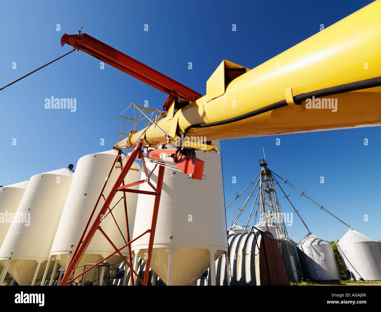 Metal grain storage silo facility against blue background Stock Photo