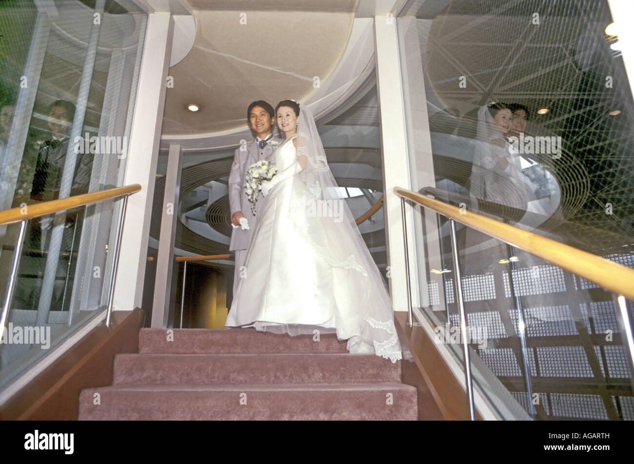 A Japanese wedding couple in Catholic church within a Hotel wearing