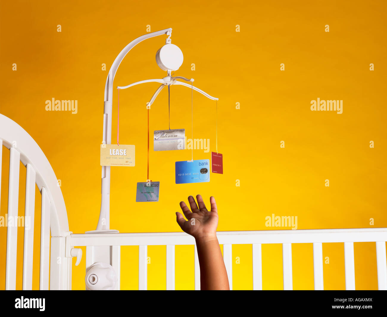 Baby's hand reaching for Mobile with credit cards horizontal Stock