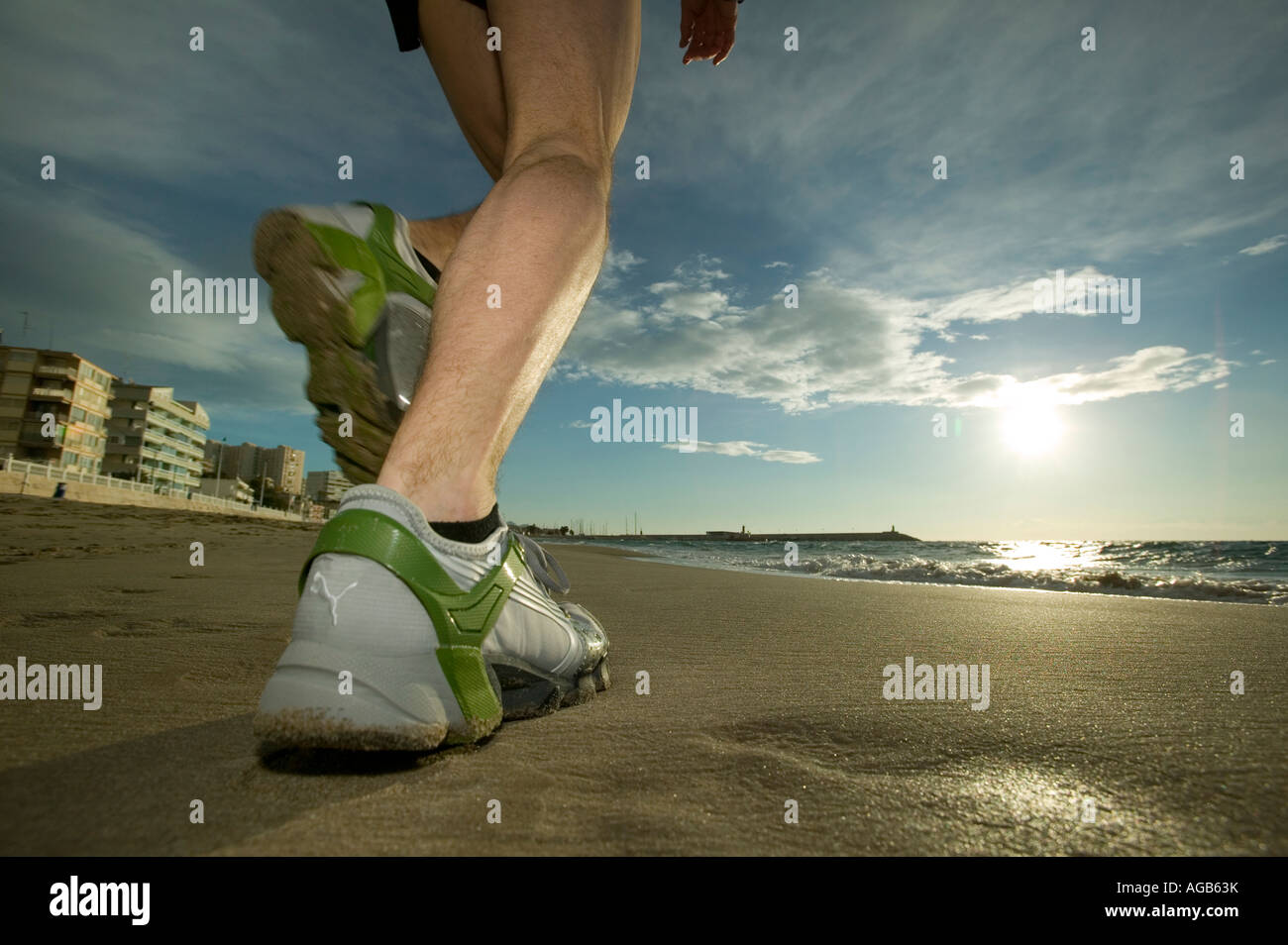 Close up of male runner s feet on beach Stock Photo