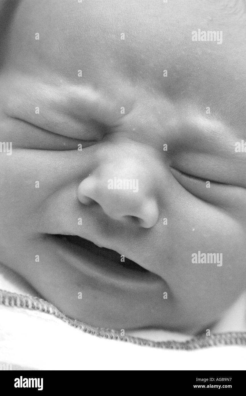 Black and white close up portrait of an infant crying Stock Photo