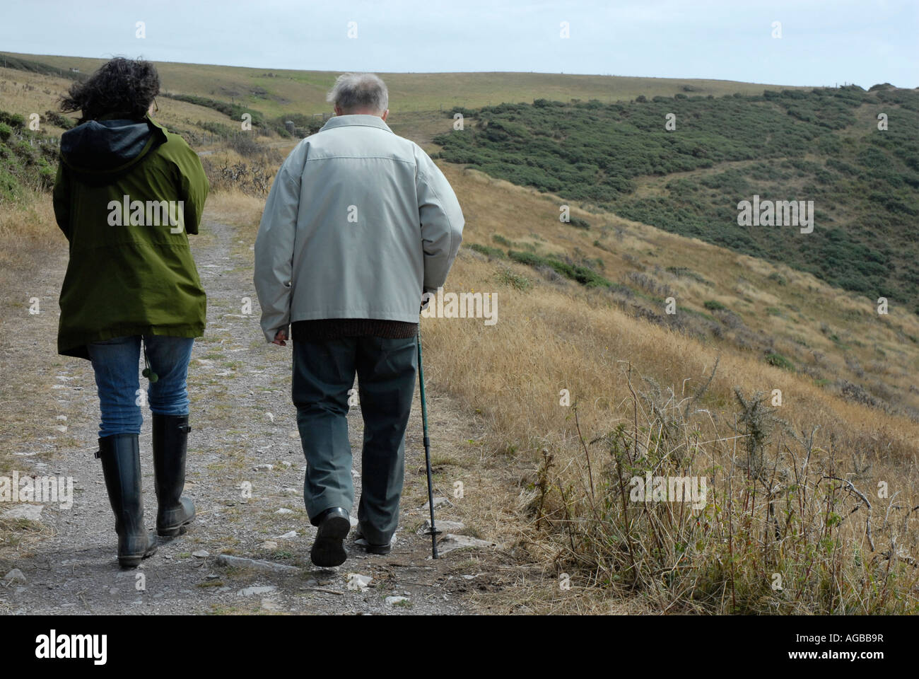 Rear view of two people walking together in the countryside Stock Photo