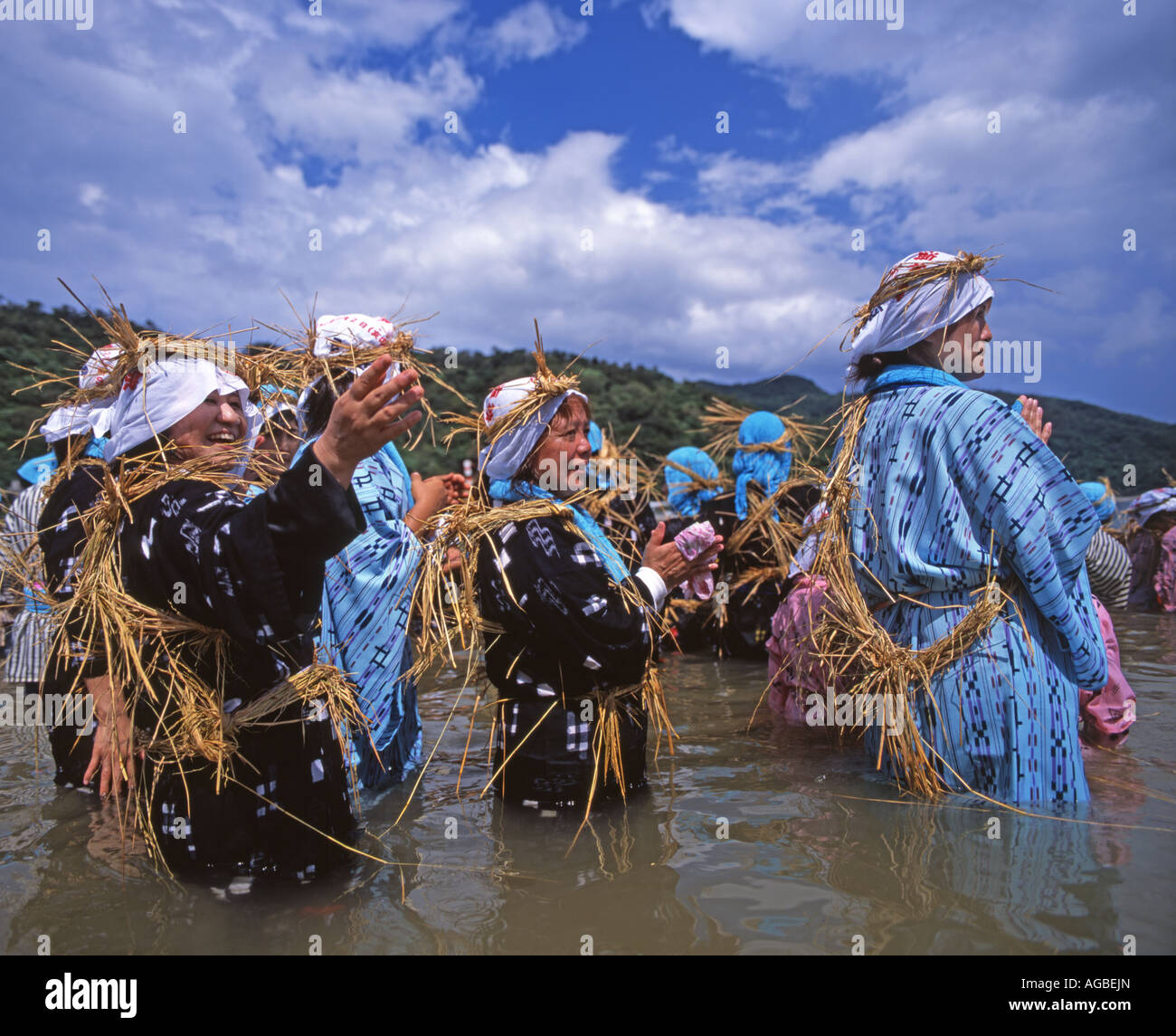 Shioya Ungami festival in Ogimi Village, Okinawa, Japan. Women stand in the ocean to welcome home the dragon boats. Stock Photo
