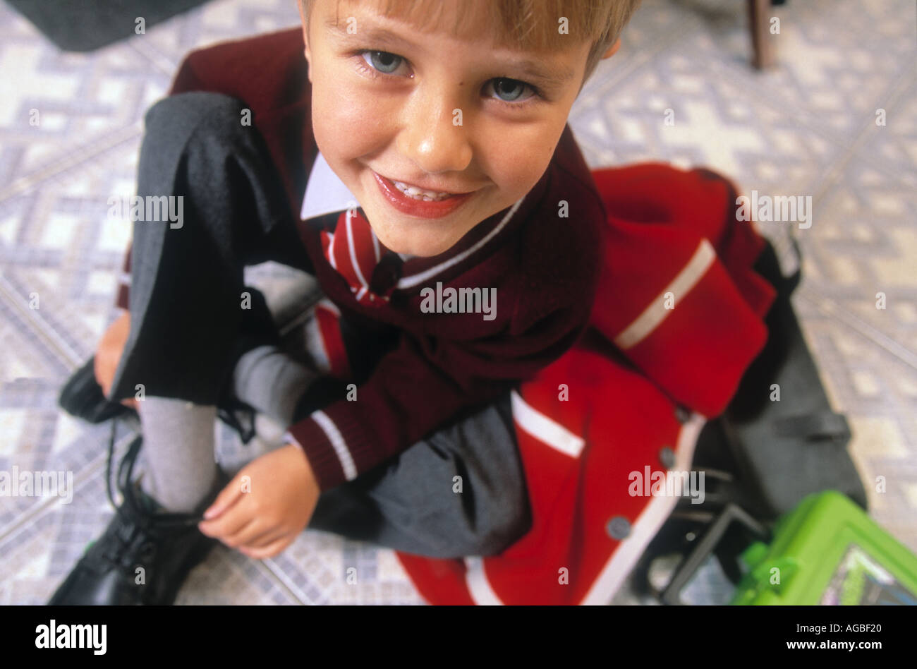 Close up of boy in school uniform tying laces on shoes Stock Photo
