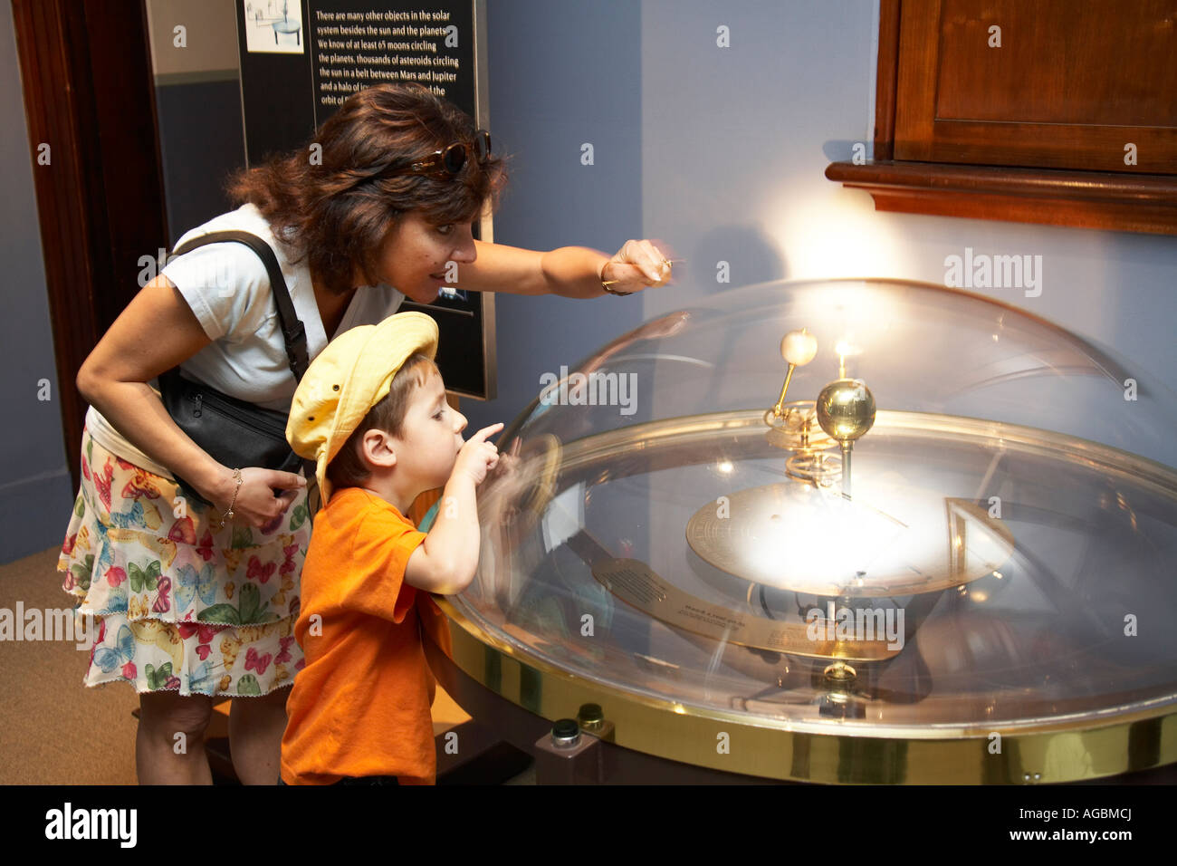 Mother and young boy child looking at Orrery scientific astronomical planetary instrument in the Observatory Sydney NSW Austral Stock Photo