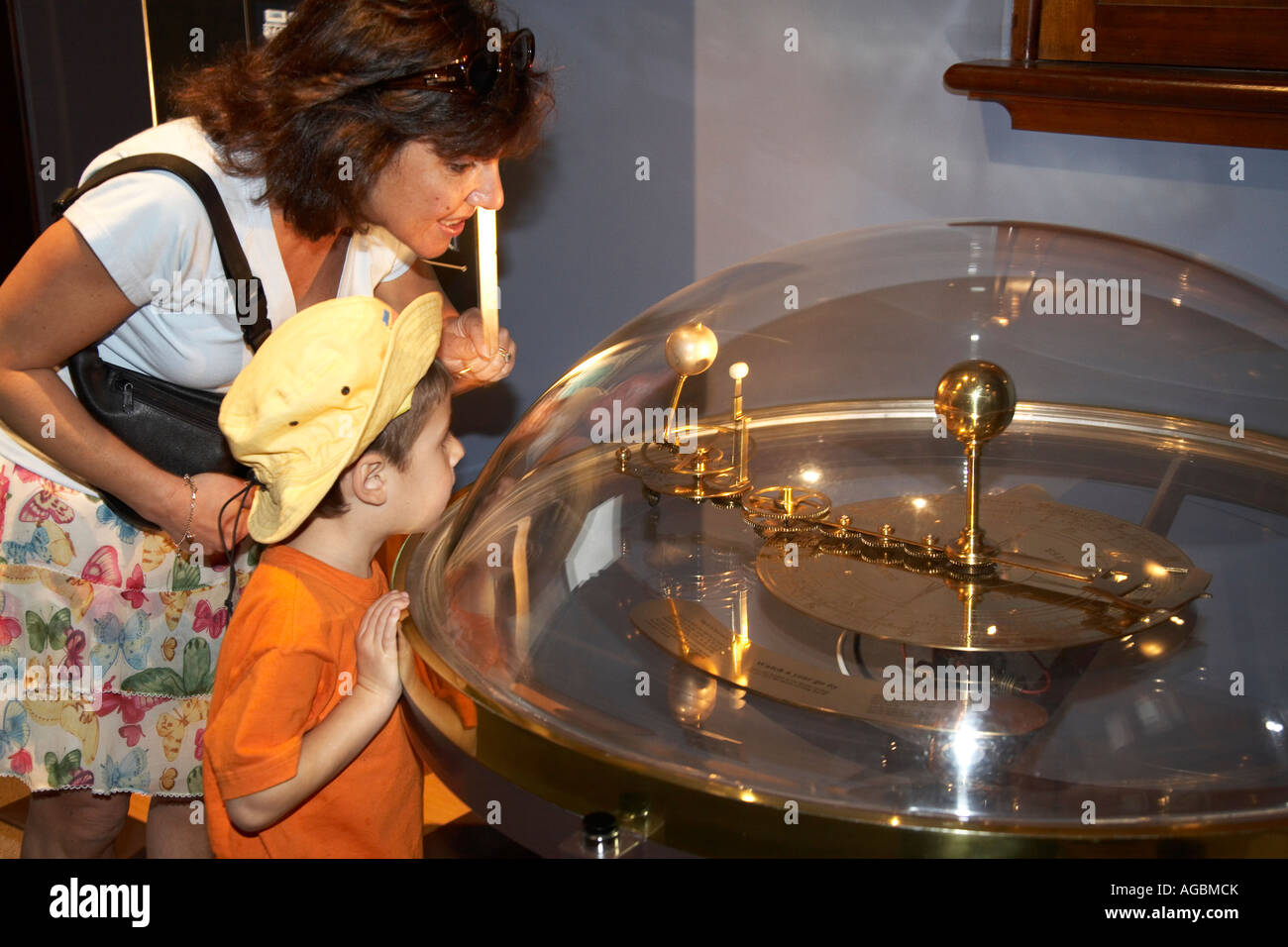 Mother and young boy child looking at Orrery scientific astronomical planetary instrument in the Observatory Sydney NSW Austral Stock Photo