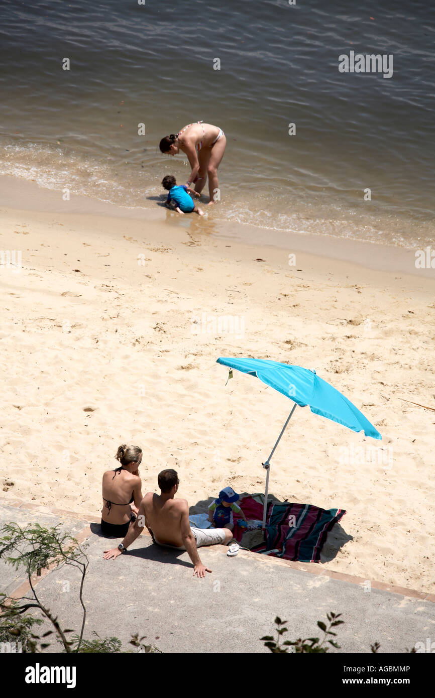 People sitting and sunbathing on the protected beach in Double Bay in Sydney New South Wales NSW Australia Stock Photo