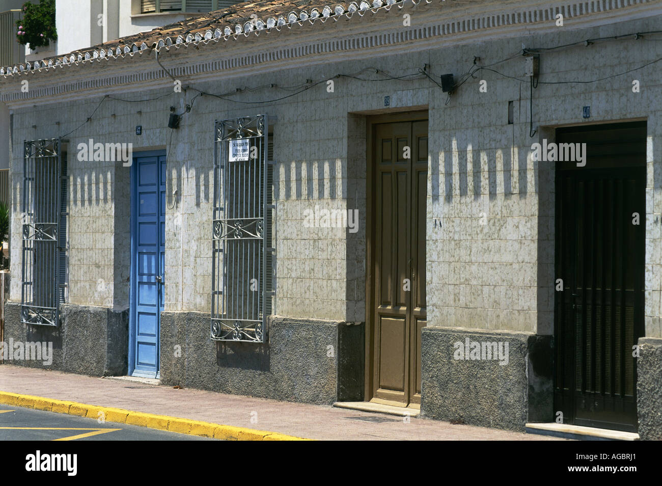 Railings barr the windows of these houses alongside the harbourfront at Aguilas Stock Photo
