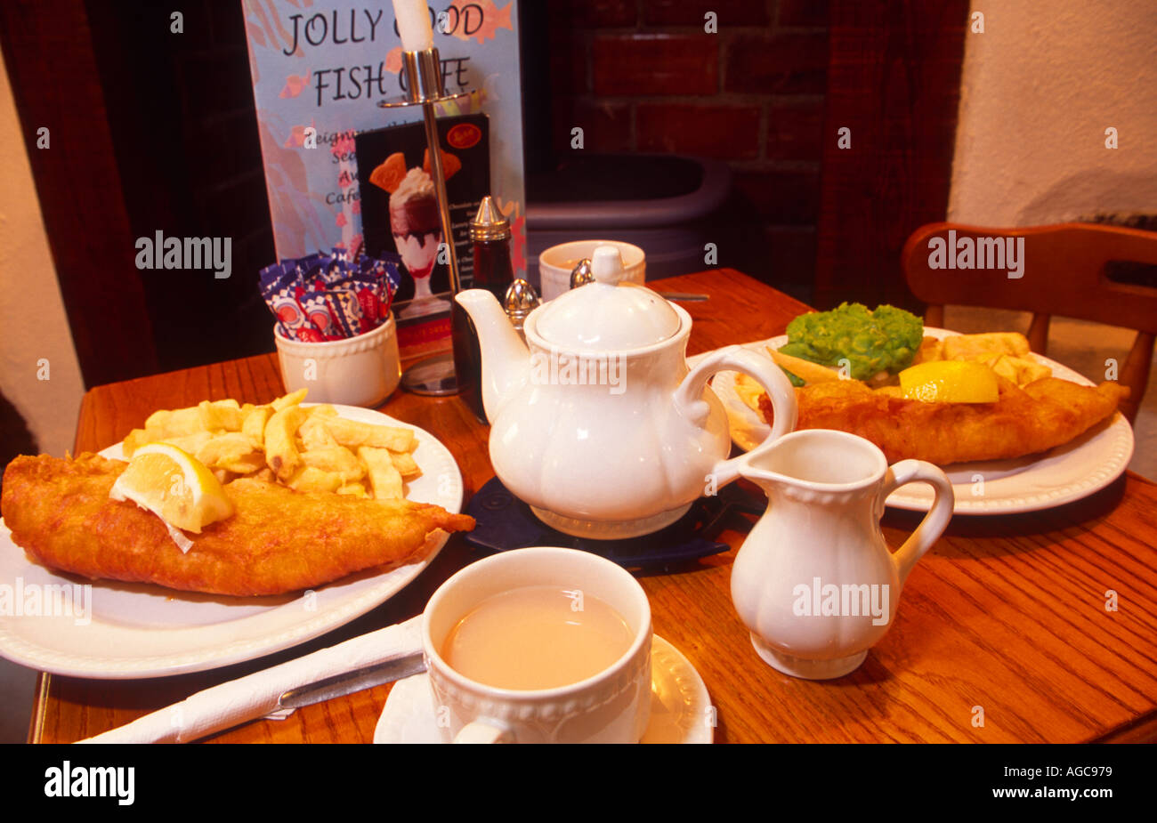 Fish and chip dinner with a pot of tea on a table at a restaurant in