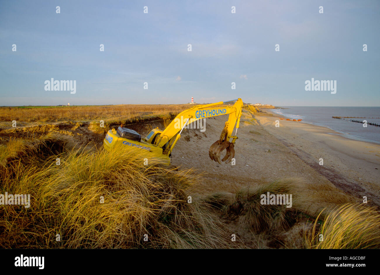 EARTH MOVER GOING DOWN ONTO BEACH FROM CLIFF TOP AT HAPPISBURGH NORFOLK ...