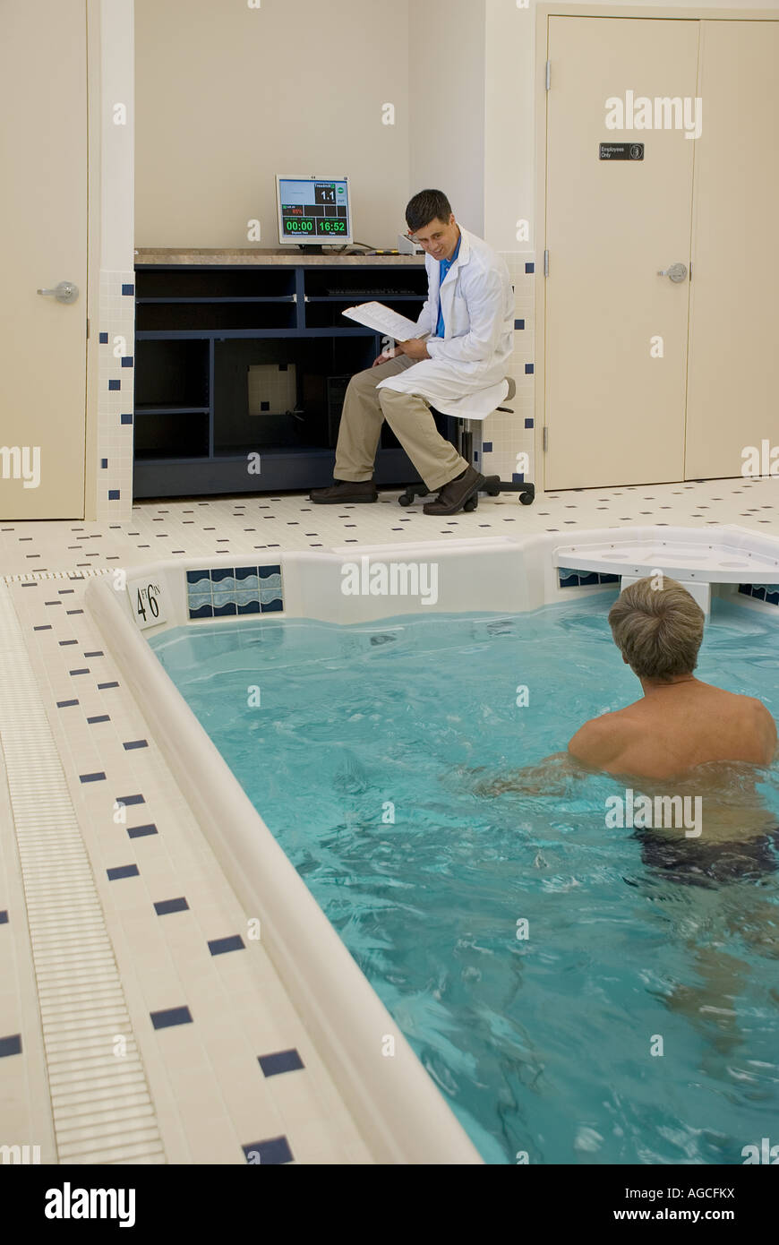 Physical therapist in lab coat monitoring middle aged male patient in