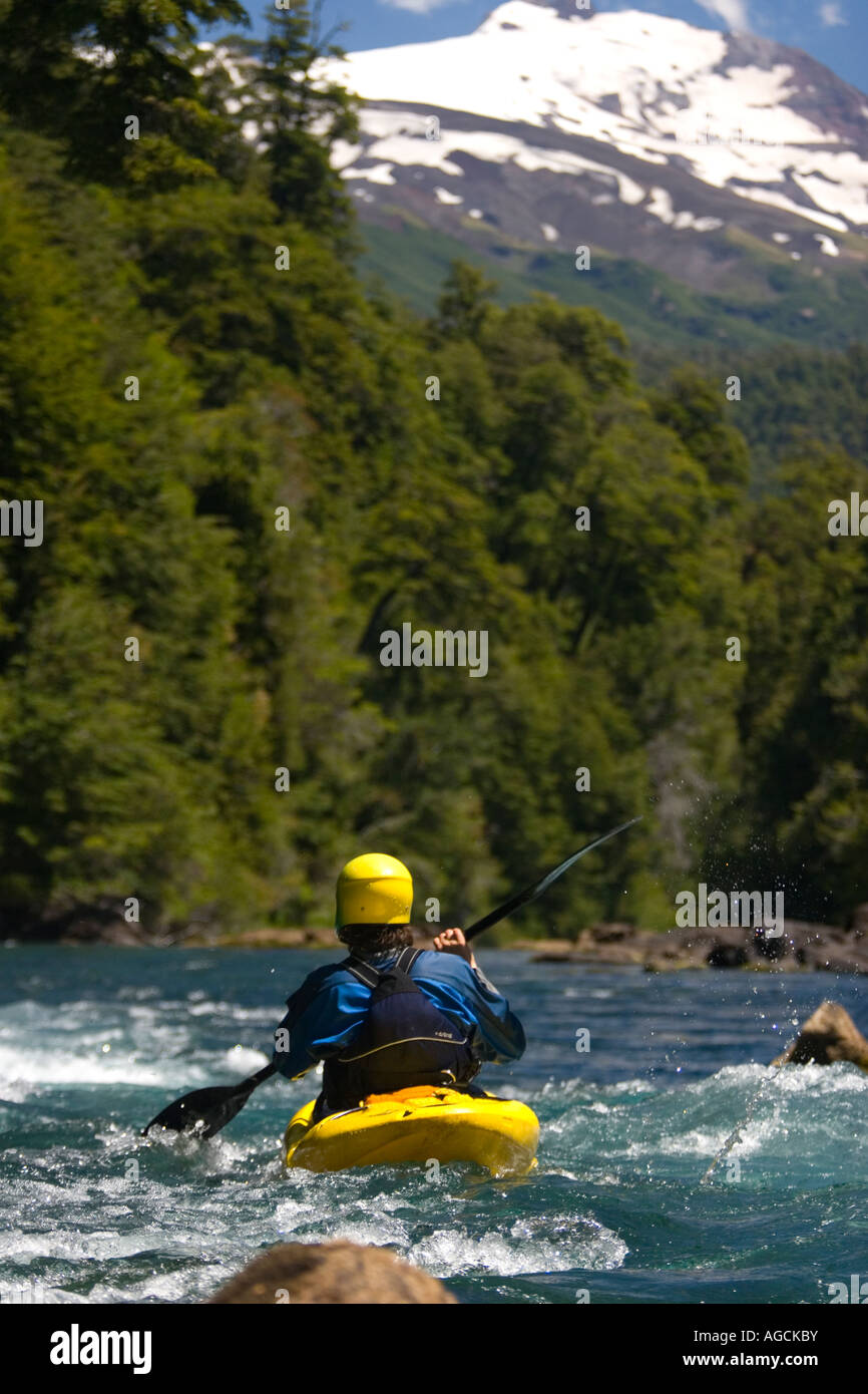 Man in yellow kayak with Volcan El Mocho beyond, Lake district Chile. Stock Photo