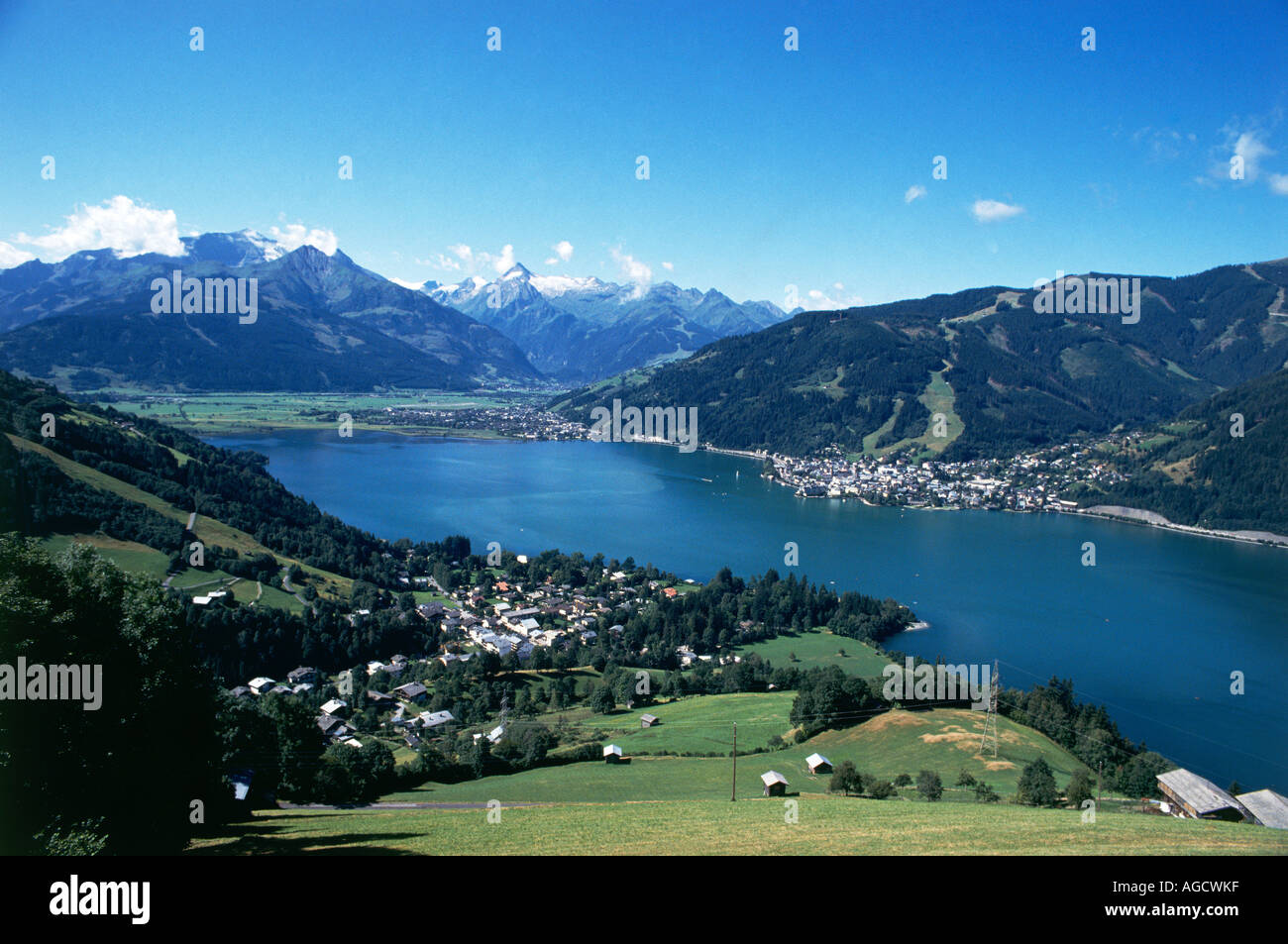 The villages of Thumersbach in the foreground and the town of Zell am Zee nestling on the western shores of the Zeller See overlooked by the the tall glacial peaks of the Hohe Tauern far to the south Stock Photo