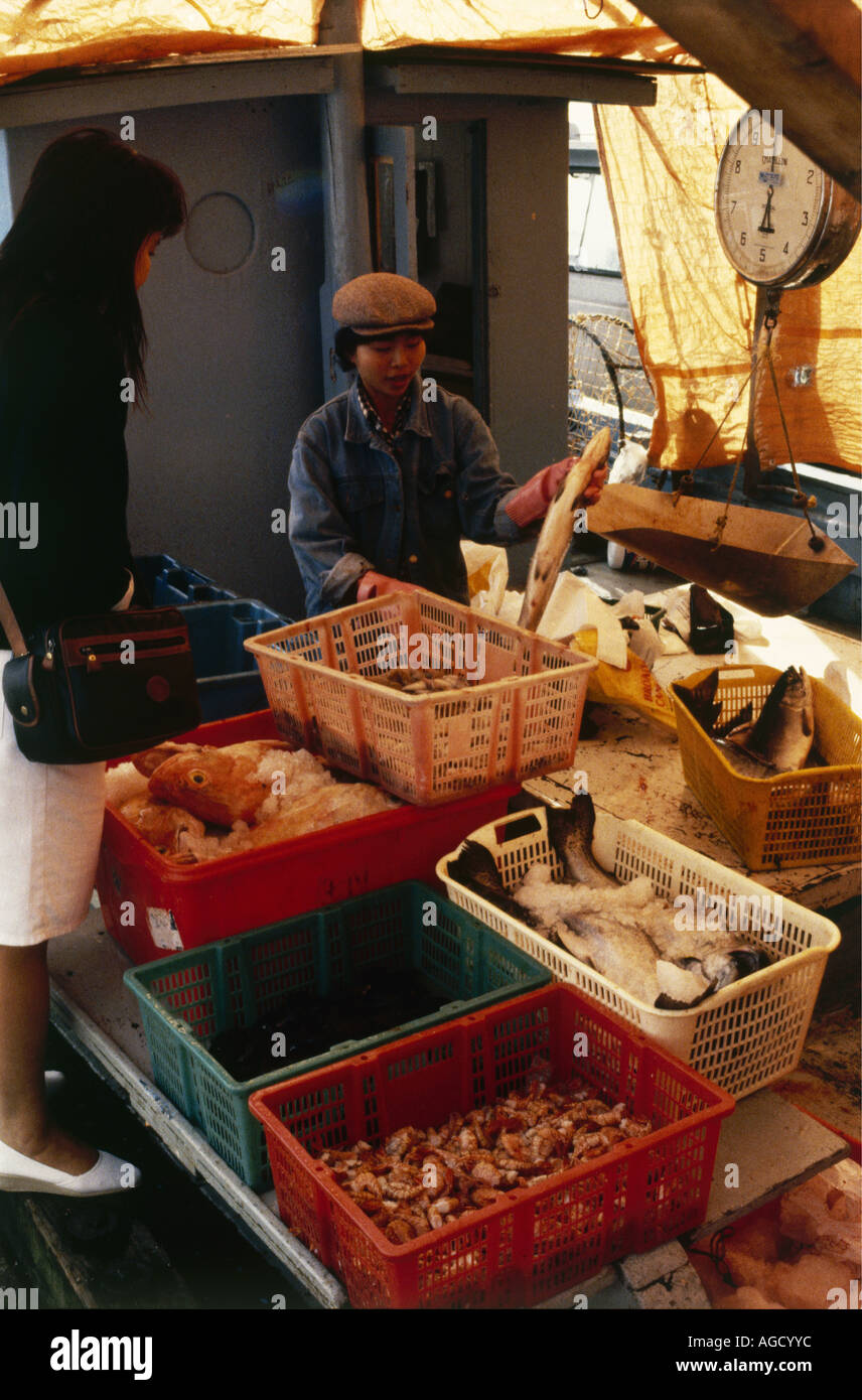 Customer inspecting the merchandise available at Vancouver s canvas covered Stevenston Fish Market Stock Photo