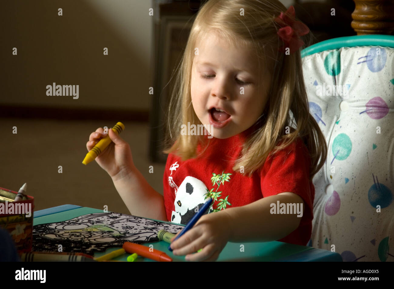 Little girl colors a picture and describes just what she is doing Stock