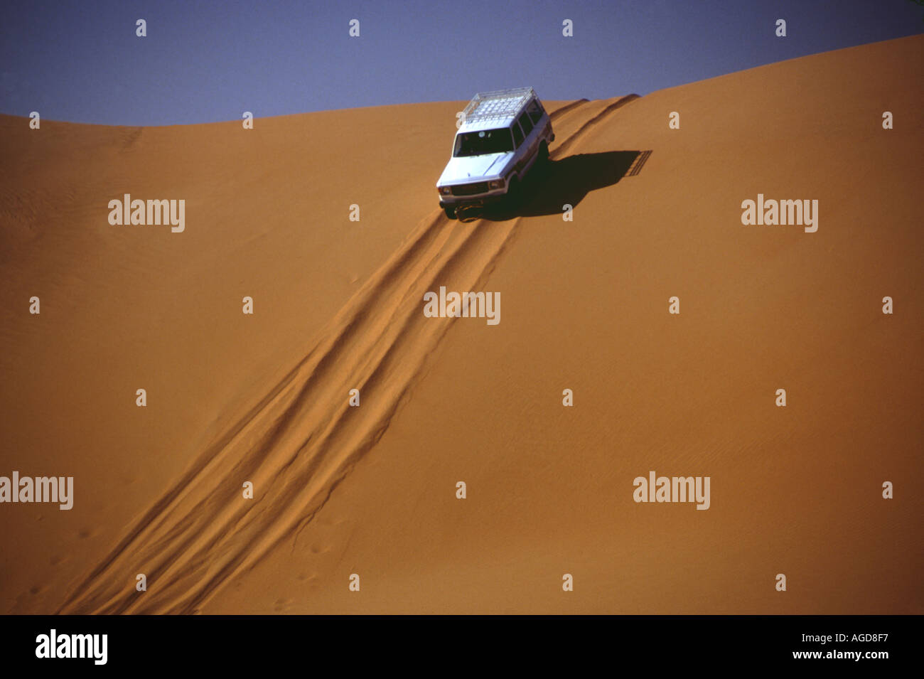 Libyen Wüstenpiste in der Sahara Jeep fährt Düne hinab Libya desert road at the Sahara Jeep crossing dune Stock Photo