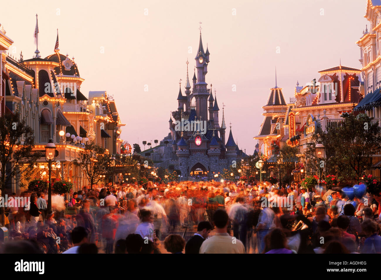The Castle with Main Street shops and people in twilight light at Euro Disney Resort outside Paris Stock Photo