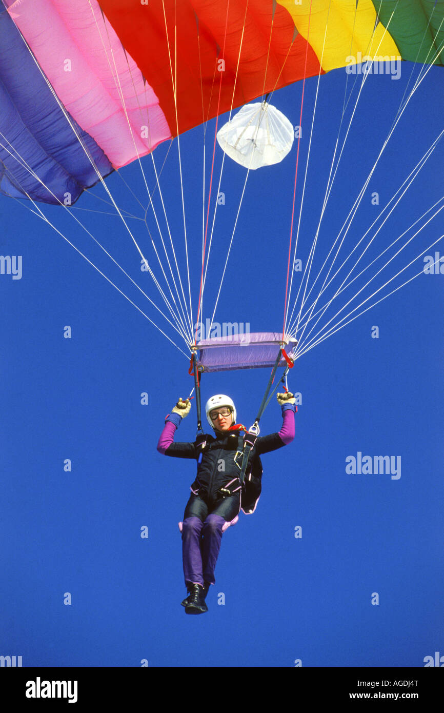Hang glider under colorful parachute floating gracefully earthward