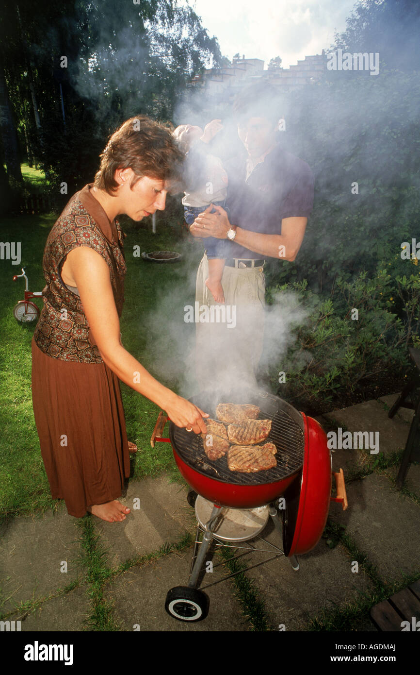 Family barbecue in backyard around steaks and smoke Stock Photo - Alamy