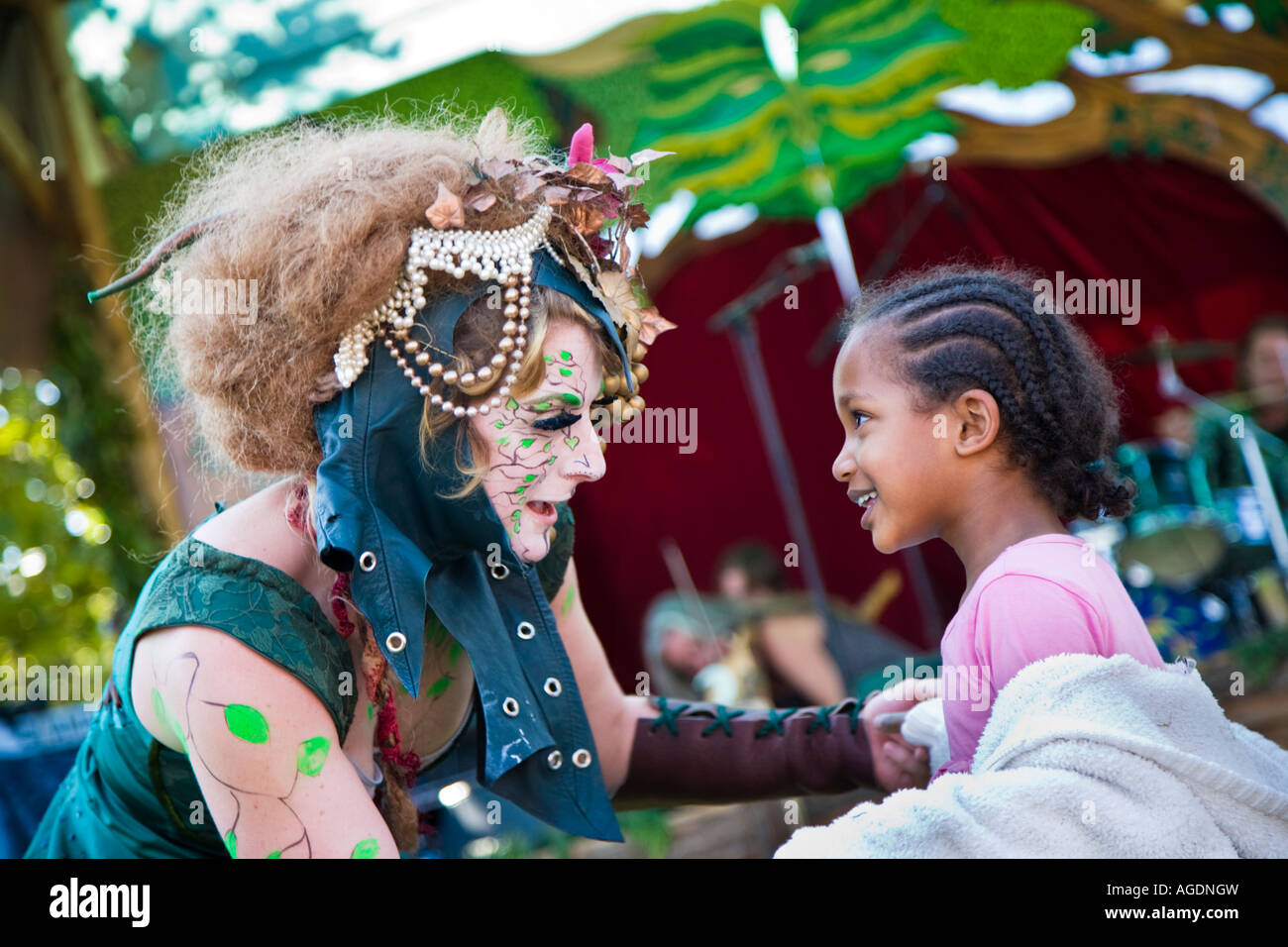 A lady advocating an eco-friendly lifestyle, and dressed as a wood nymph, dances with a pretty young girl at the Thames Festival Stock Photo