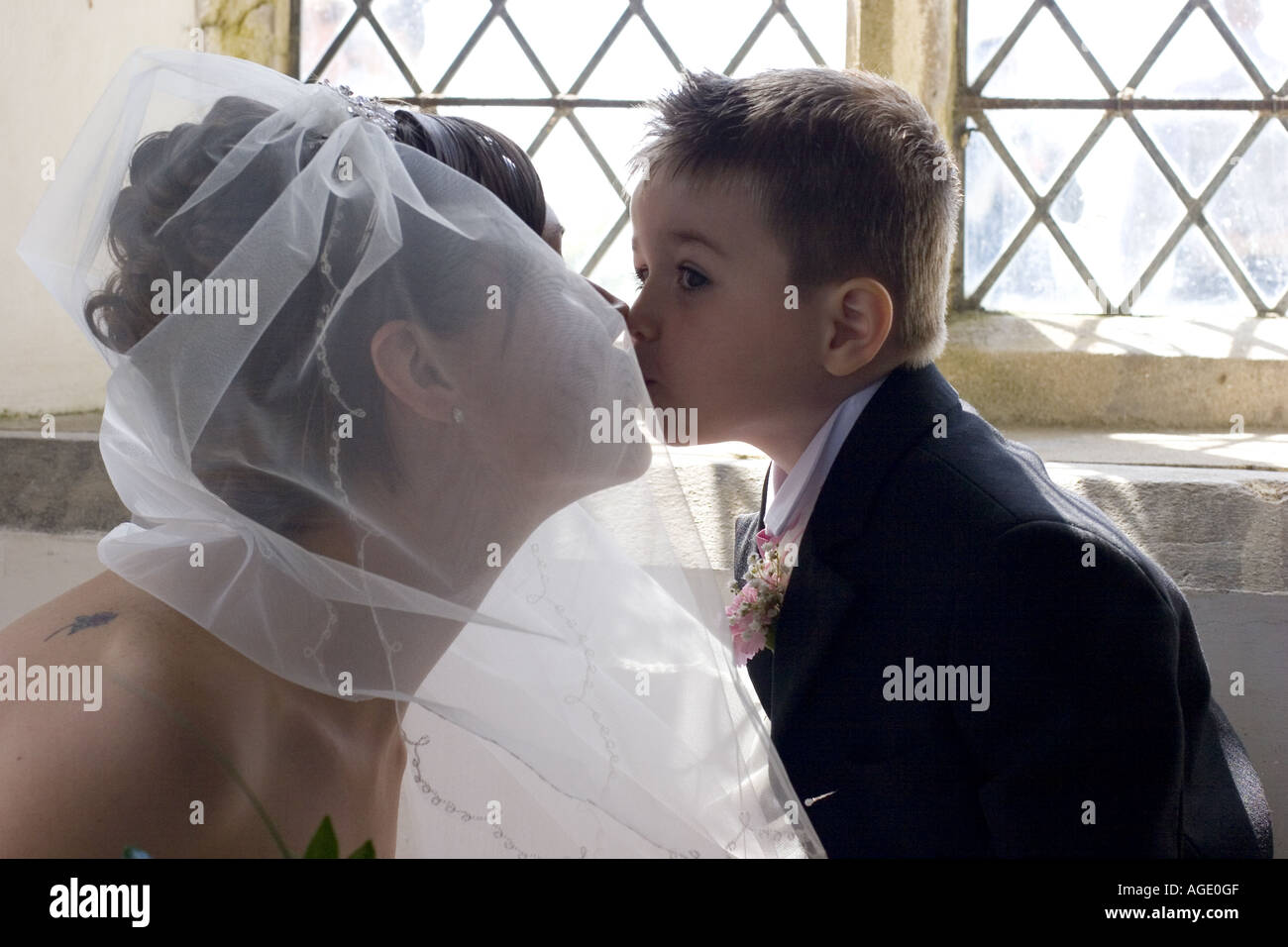 Bride kissing her pageboy inside church Stock Photo