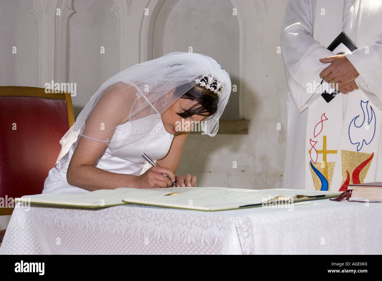 Bride signing wedding register in English parish church Stock Photo Alamy