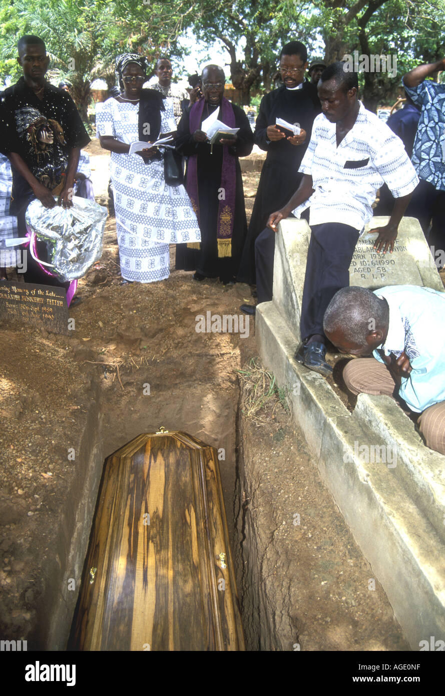 Mourners at a graveside with priest, Christian funeral service in Accra, Ghana Stock Photo