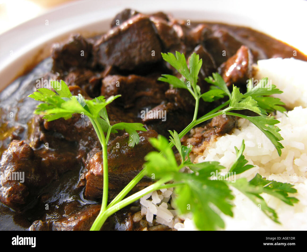 Beef curry with rice and parsley garnish Stock Photo