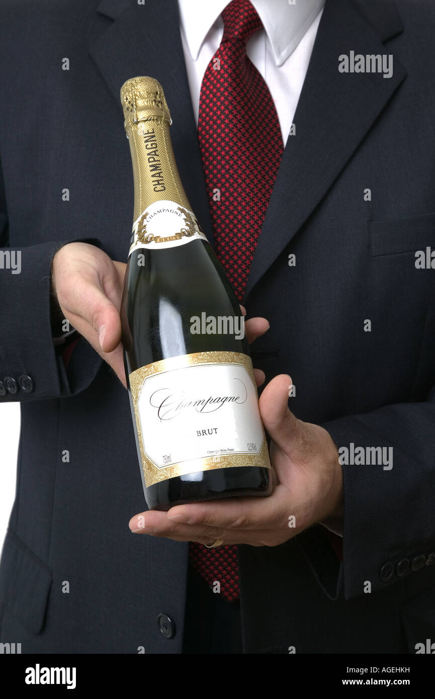 Bottle of champagne being presented by a businessman All labels have been substantially altered to avoid copyright issues Stock Photo