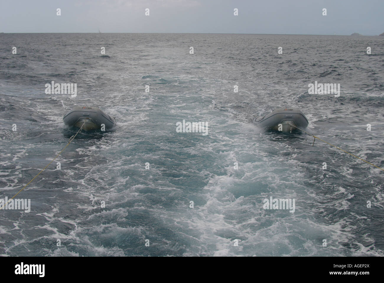 Two dinghies race behind a large motor yacht in St Thomas US Virgin