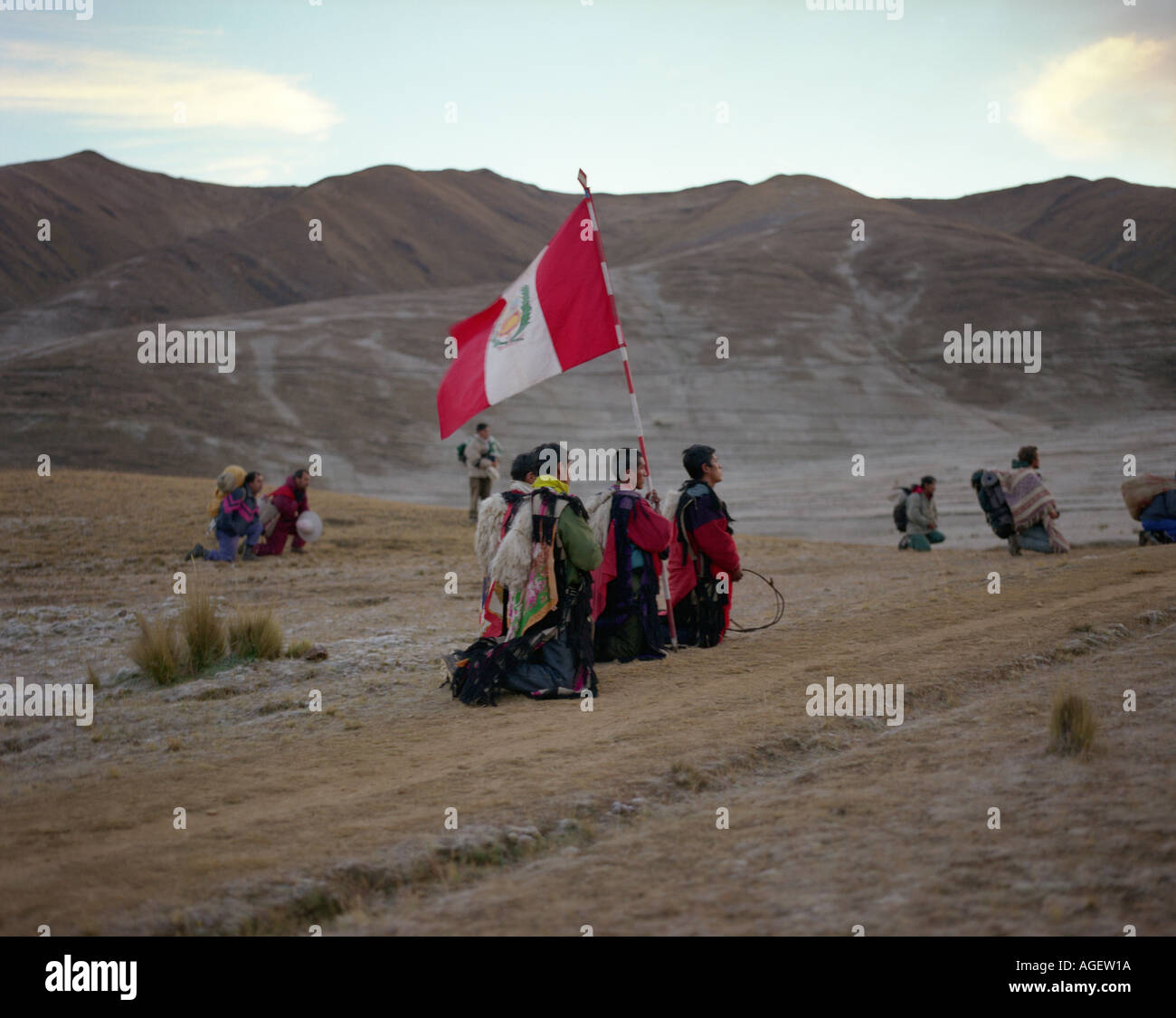 Peruvians holding a flag in traditional costume at the Festival De Qoylluriti in the  mountains of Peru Stock Photo