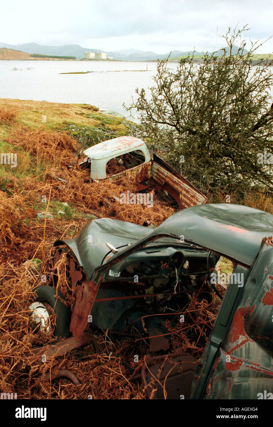 Rusting vehicles on the shore with the Magnox reactor at Trawsfynydd in background Stock Photo