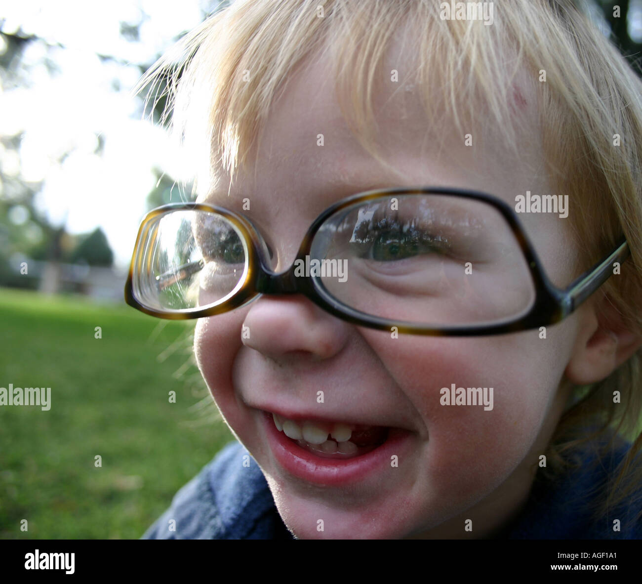 child smiling with upside down adult glasses Stock Photo Alamy