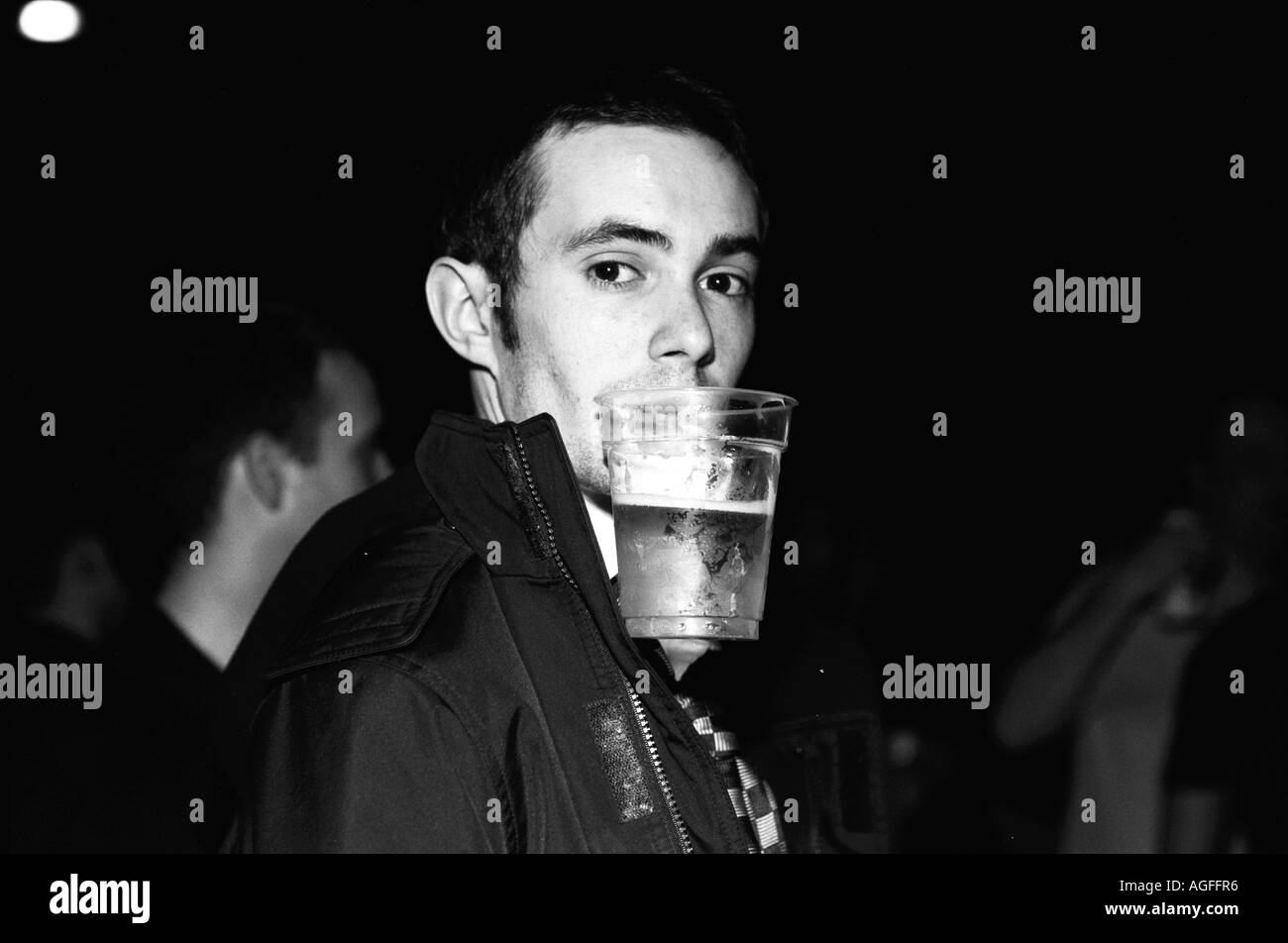 Bloke with cup of beer in his mouth at Leftfield gig at Manchester Arena Stock Photo