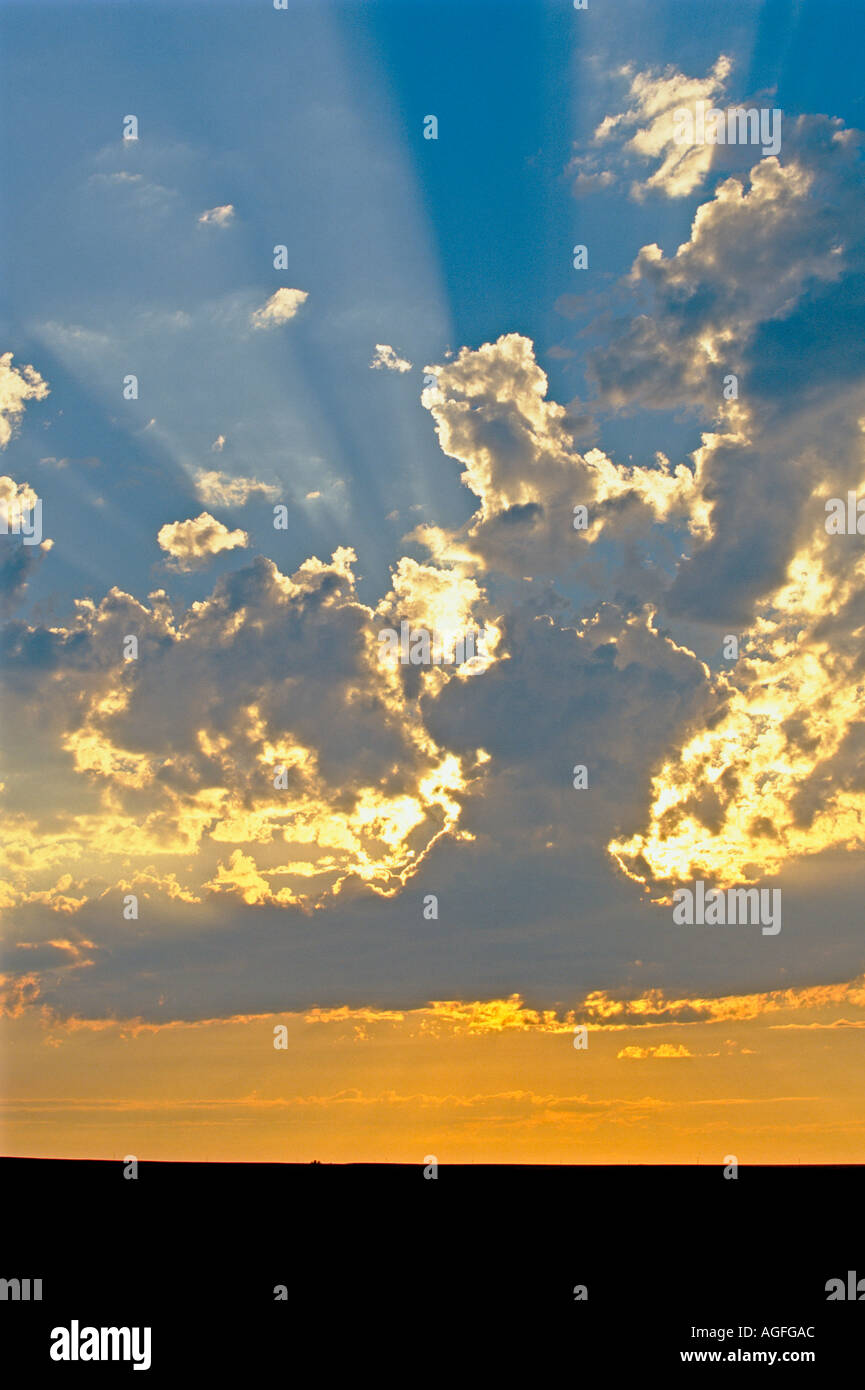 Sun beams and clouds at sunset over silhouetted prairie near Drumheller Stock Photo