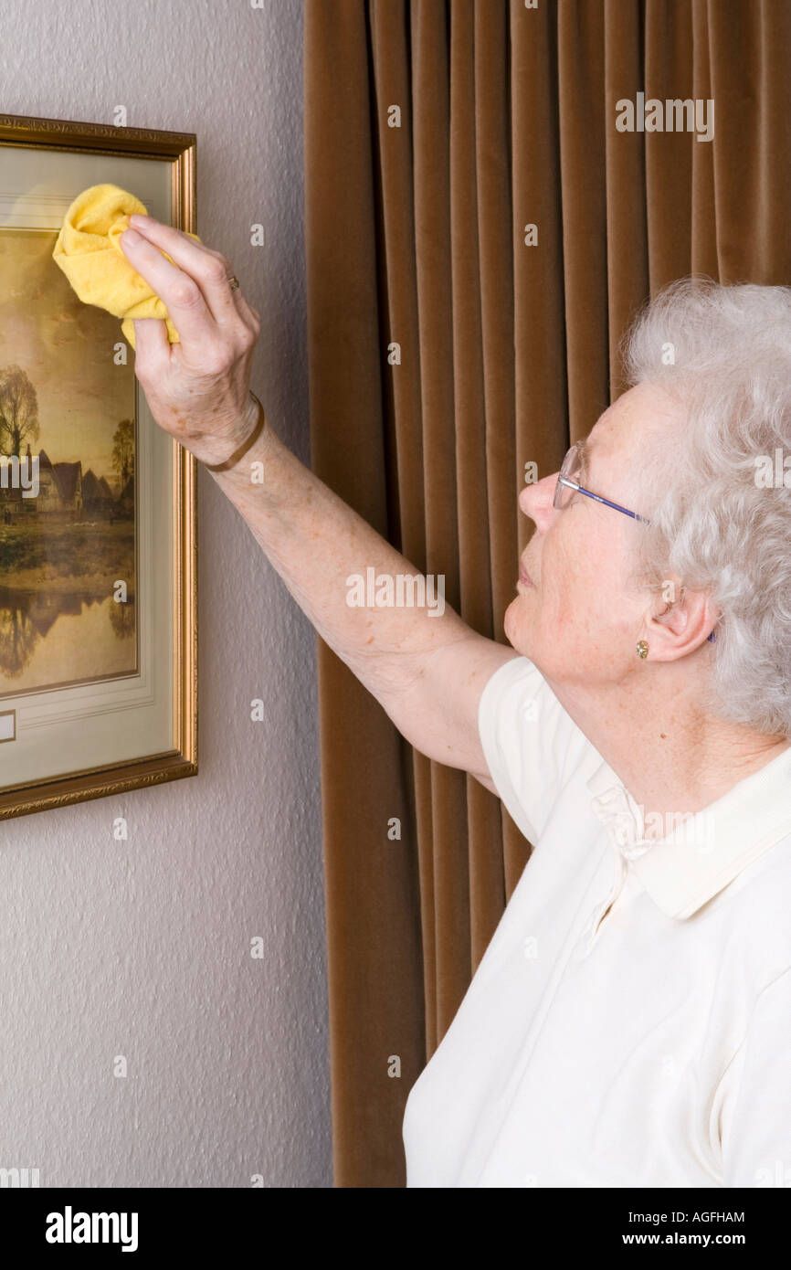 Elderly woman dusting cleaning housework uk hires stock photography