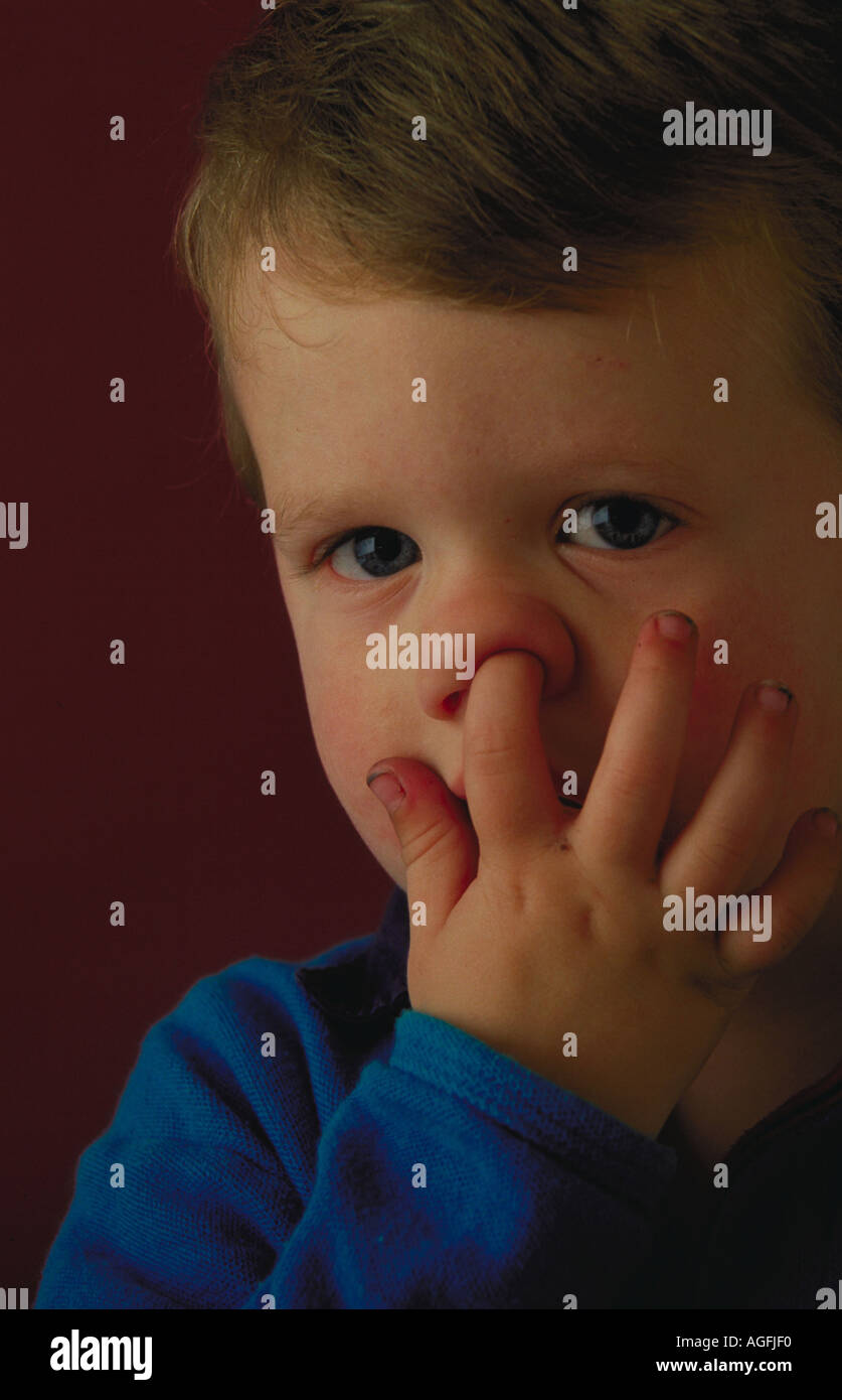 Portrait of a young boy with his finger in his nose Stock Photo