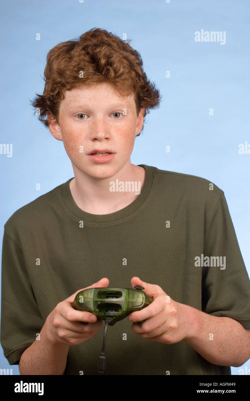 Redhead freckled boy 14 with Play Station Stock Photo