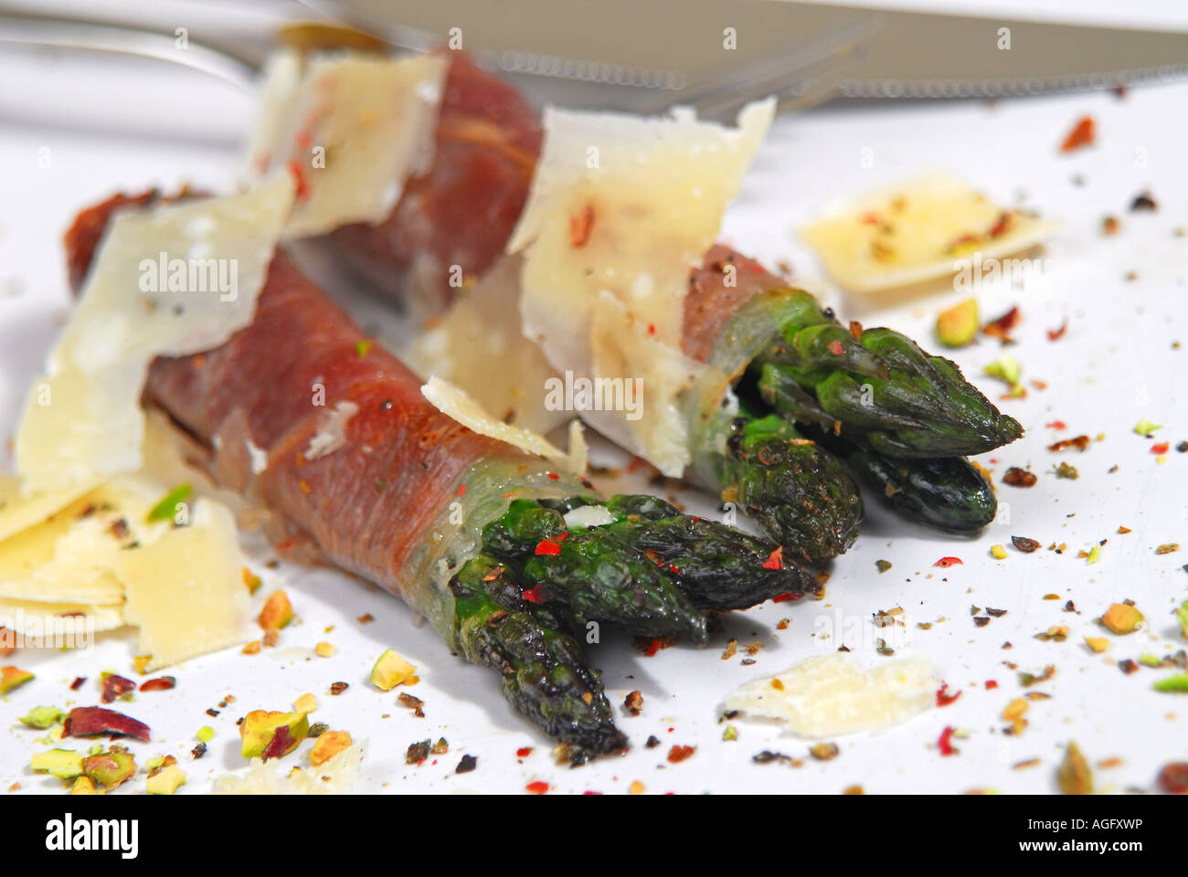 Asparagus wrapped in Parma ham with parmesan shavings, crushed