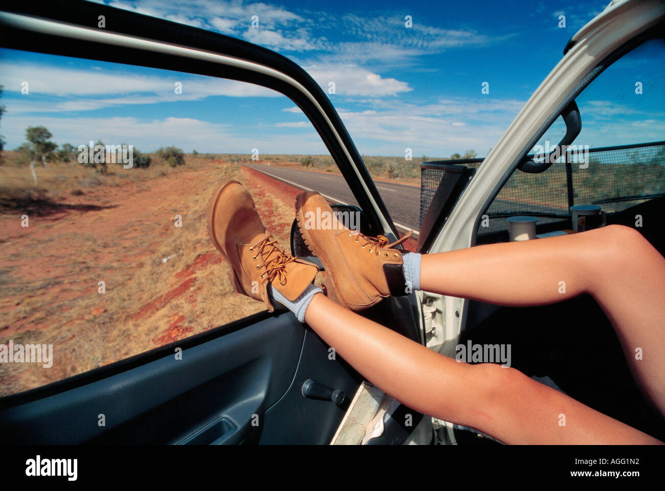 legs resting on door to a camping van, Northern Territory, Australia Stock Photo